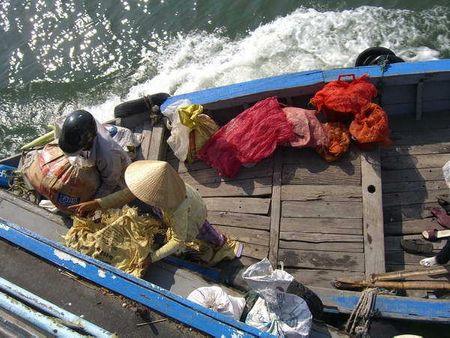 Một cảnh thuyền nhỏ chuyển hàng lên thuyền lớn khi tàu đang chạy rất nhanh.