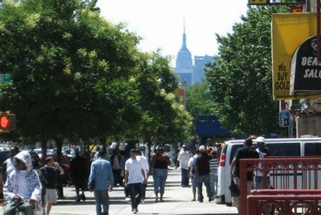 Trên một con đường nơi diễn ra Lễ hội Harlem. Lễ hội này được tổ chức trong khu Manhattan, New York. Toà nhà cao nhất là Empire State.
