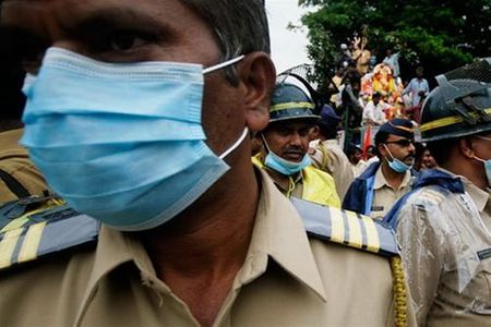 Cảnh sát ở Mumbai đeo khẩu trang để tránh chất độc hại. Hằng năm họ phải kiểm soát và bảo vệ một lượng người khổng lồ đến tham dự lễ hội: con số người dự hội có tới hàng triệu người